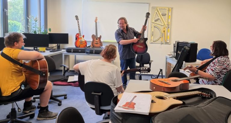 musiker-und-projektleiter-jens-dammann-stellt-schuelern-eine-westerngitarre-vor