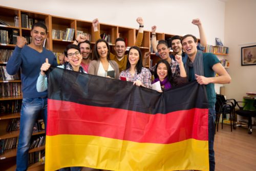 students-with-hands-raised-and-smiling-faces-present-german-coun