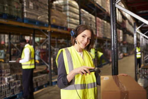 woman-using-a-barcode-reader-in-a-warehouse-looks-to-camera