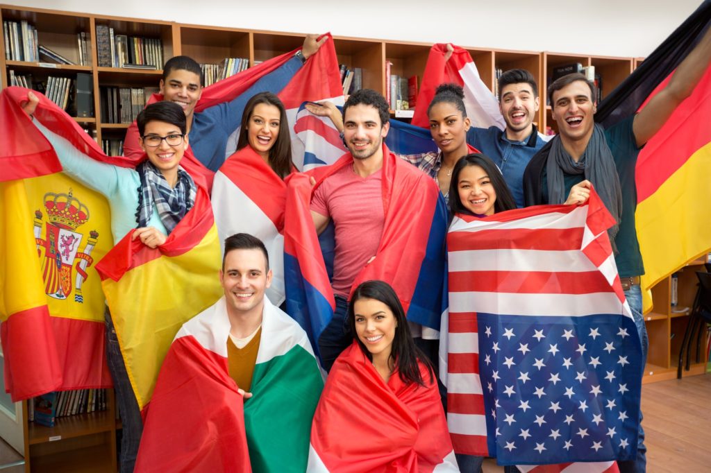 International multiethnic exchange of students, happy students presenting their countries with flags