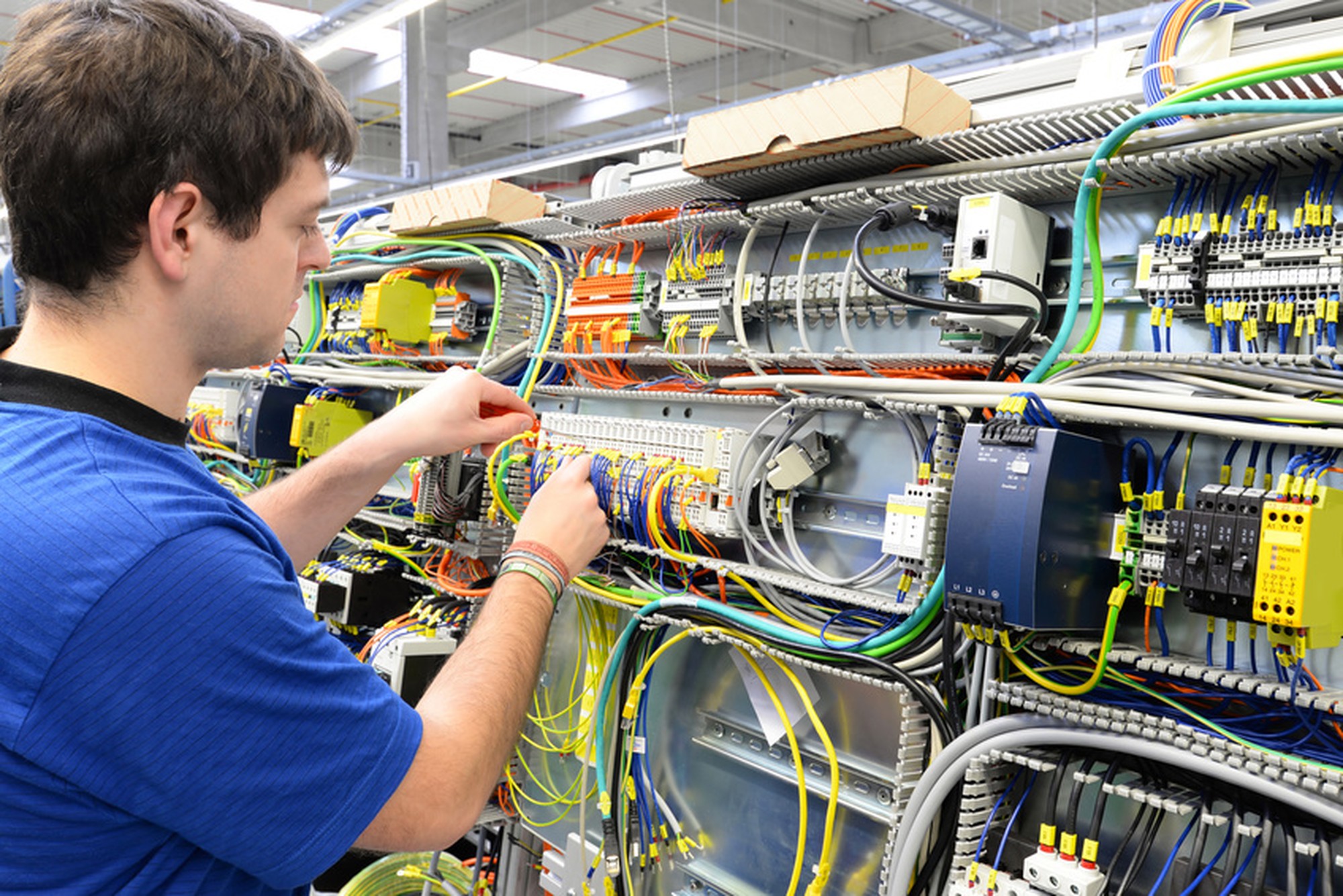Elektroniker im Maschinenbau montiert Schaltschrank in einer Fabrik // workers mounted electronics in a factory