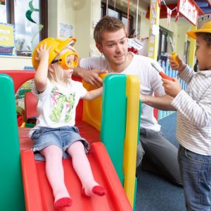 man-with-nursery-children-playing-together
