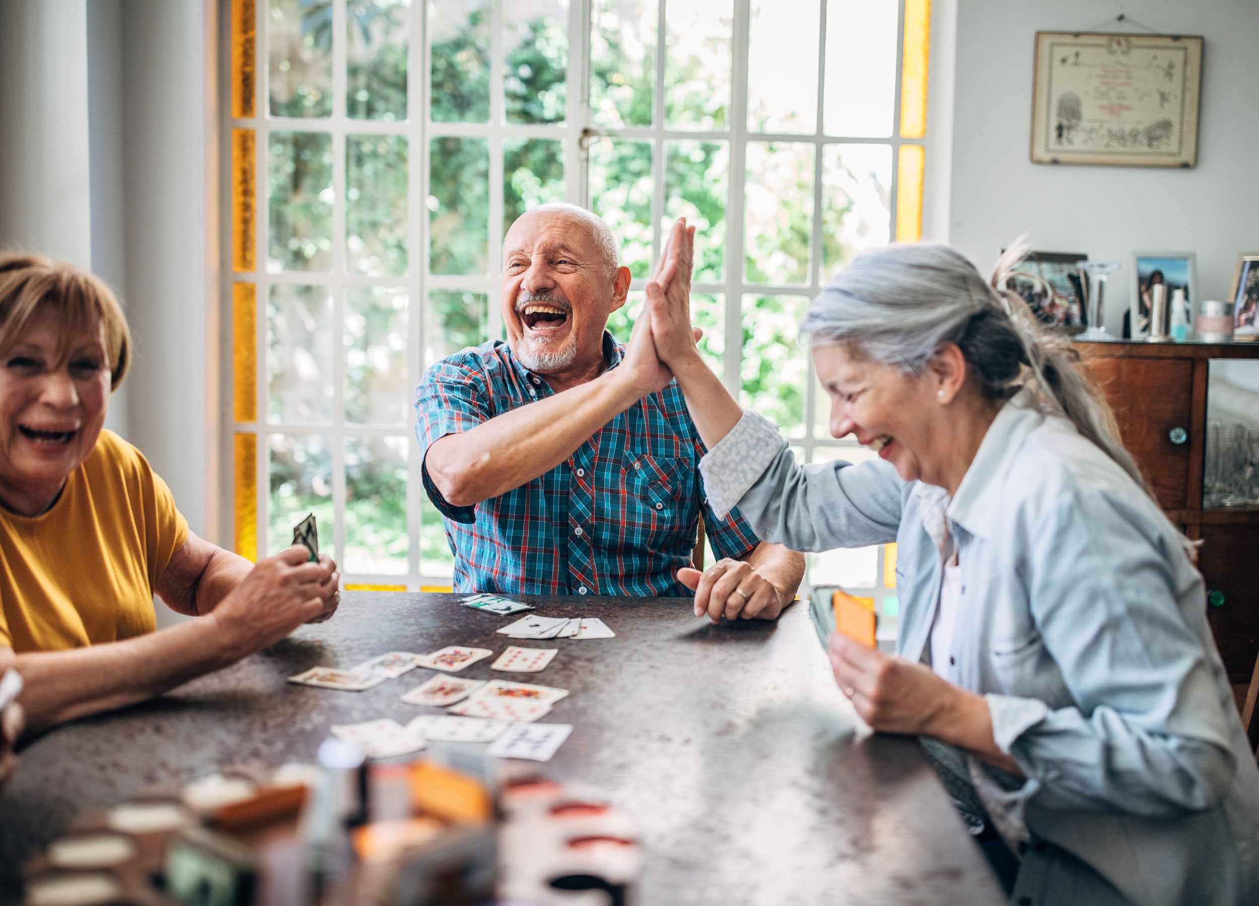 Senior people playing cards in nursing home