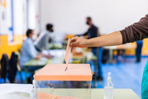 autonomous-community-of-madrid-elections-democraty-referendum-for-government-vote-hand-posing-an-envelop-in-a-ballot-box-for-community-elections