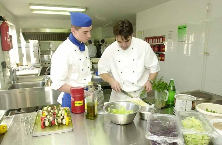 a couple of chefs in a kitchen