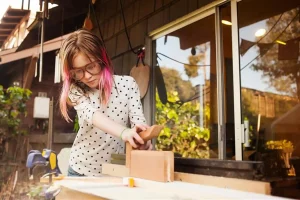 Mädchen arbeitet an einer Holzwerkbank