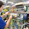 Elektroniker im Maschinenbau montiert Schaltschrank in einer Fabrik // workers mounted electronics in a factory