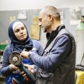 technician explains a grinder to a female trainee in a workshop